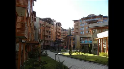 a city street with tall buildings and a road at Private Apartment Maxim in Bansko