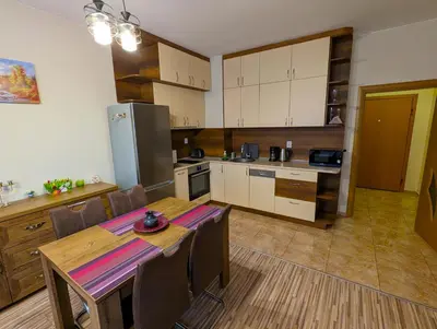 a kitchen with a table and a kitchen with a refrigerator at Business and Leisure apartments in Mladost 2 with FREE Garage in Sofia