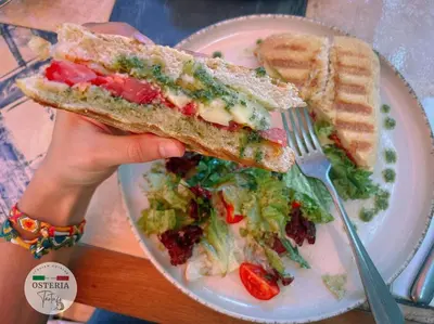 a person holding a sandwich and a salad on a plate at Urban Eden - LUX & STYLE, 2-Bedroom, 2-Bathroom in Sofia