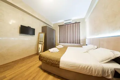 a hotel room with a bed and a flat screen tv at Sofia Crown Life Apartment in Sofia