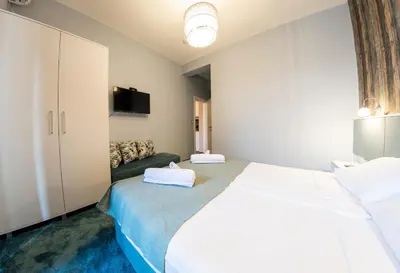 a bedroom with a large white bed and a couch at Sofia Artist Life Apartment in Sofia