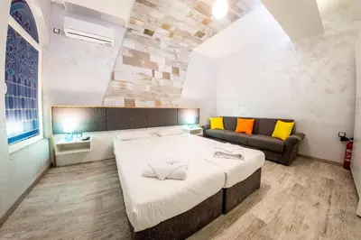 a bedroom with a large bed and a couch at Sofia Colour Life Apartment -No Window Apartment in Sofia