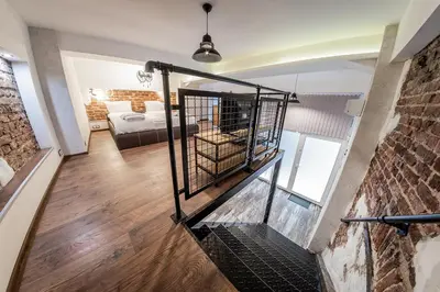 a staircase in a loft with a bed and a brick wall at Sofia Parter Life Apartment in Sofia