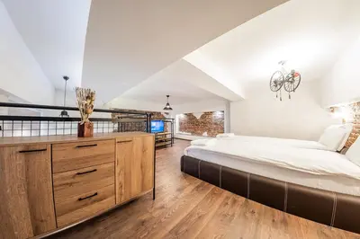 a large bedroom with a large bed and a staircase at Sofia Parter Life Apartment in Sofia