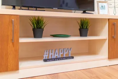 a shelf with a happy sign and two potted plants at Domus Apartments Grand with Parking in Plovdiv
