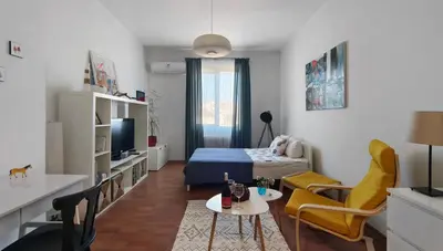 a small living room with a bed and a table at Cozy apartment in the historical center of Sofia in Sofia