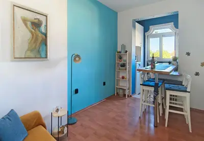 a living room with a table and a blue wall at Cozy apartment in the historical center of Sofia in Sofia