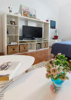 a living room with a table and a tv at Cozy apartment in the historical center of Sofia in Sofia