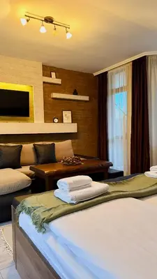 a bedroom with two beds and a living room at Deluxe 707 in Borovets
