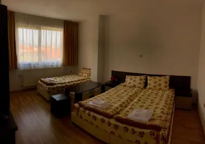 a hotel room with two beds and a window at Къща за гости Александра in Dobrinishte