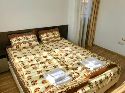 a bed with two pillows on it in a bedroom at Къща за гости Александра in Dobrinishte