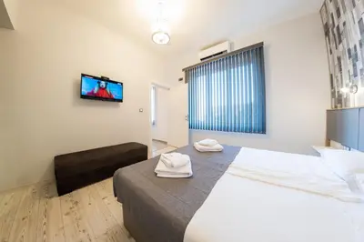 a bedroom with a large bed and a tv on the wall at Sofia Downtown Life Apartment in Sofia