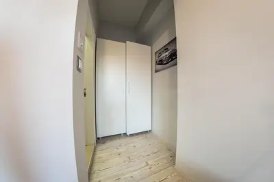 an empty hallway with a white door and wooden floors at Sofia Downtown Life Apartment in Sofia
