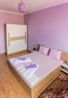 a bedroom with a large white bed with pink pillows at Apartment Petya in Velingrad