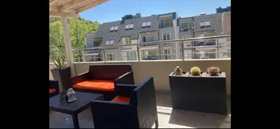 a balcony with chairs and a table and a building at Sunpark Apartment in Sandanski