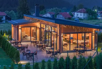 a glass house with tables and chairs on a patio at Samovilla in Govedartsi