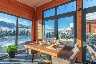 a dining room with a table and views of snow covered mountains at Samovilla in Govedartsi