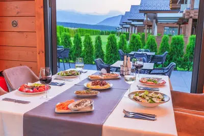 a table with plates of food and glasses of wine at Samovilla in Govedartsi