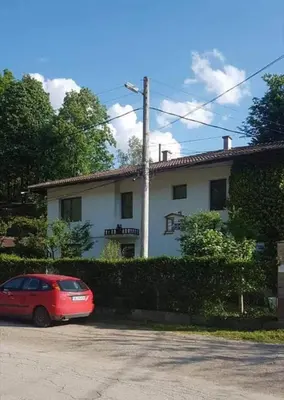 a red car parked in front of a white house at Вила Керенски in Ribarica