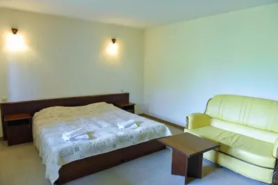 a hotel room with a bed and a couch at Lovna sreshta in Bansko