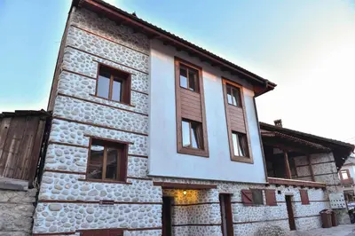 a stone building with windows on the side of it at Lovna sreshta in Bansko