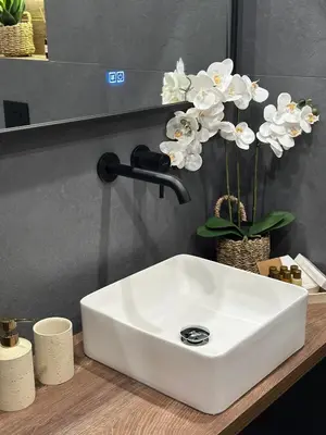 a white sink on a counter with white flowers at Deluxe 217 in Borovets