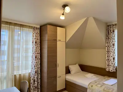 a small bedroom with a bed and a window at Хостел Атлас - Hostel Atlas in Blagoevgrad