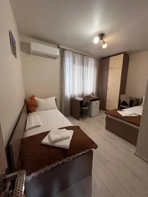 a hotel room with two beds and a desk at Хостел Атлас - Hostel Atlas in Blagoevgrad