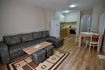 a living room with a couch and a table and a kitchen at City Apartments in Velingrad
