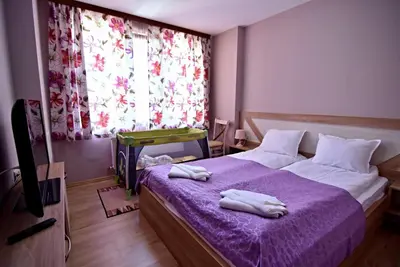 a bedroom with a purple bed with towels on it at City Apartments in Velingrad