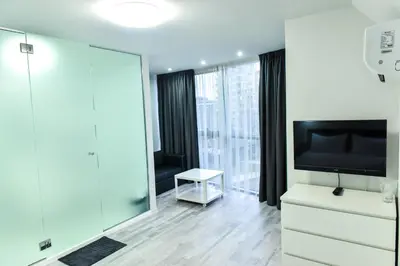 a living room with a tv and a large mirror at Стаи за гости Десита in Blagoevgrad
