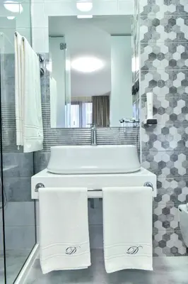 a bathroom with a sink and a tub and towels at Стаи за гости Десита in Blagoevgrad