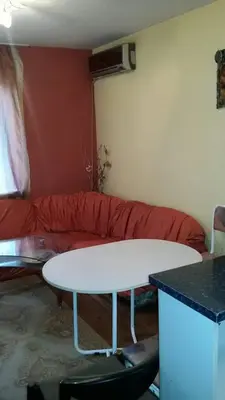 a living room with a table and a red couch at encanto in Plovdiv