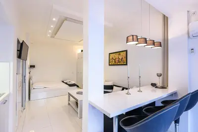 a room with a white counter and blue chairs at Zero-Waste Studio Apartment in Central Sofia in Sofia