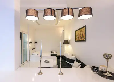 a white room with a bed and a living room at Zero-Waste Studio Apartment in Central Sofia in Sofia