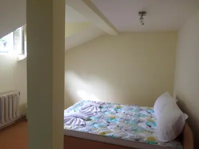 a small bed in a room with a bed sidx sidx sidx at Семеен Хотел 