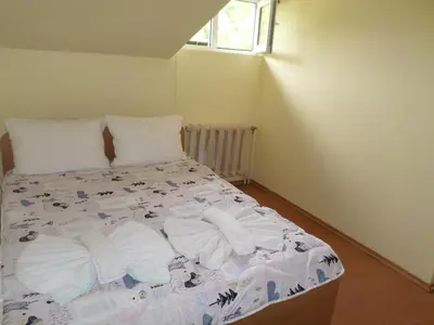 a bed in a small room with towels on it at Семеен Хотел 