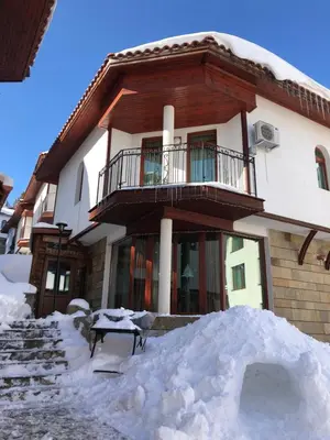 a house with a pile of snow in front of it at Pamporovo Villa in Pamporovo
