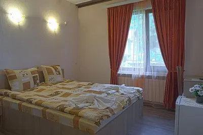 a bedroom with a large bed in front of a window at СТАР МЕРАК in Ribarica