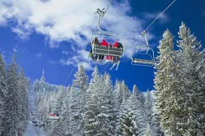 a group of people riding a ski lift in the snow at VIVA Flora apartment 607A in Borovets