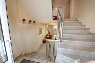 a staircase in a building with a person sitting on a couch at Best Rest Guest Rooms in Plovdiv