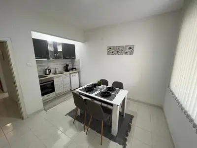 a kitchen with a table and chairs in a room at Апартамент Рози in Sandanski