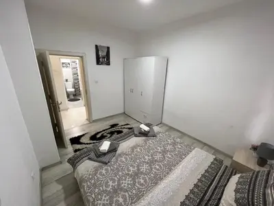 a bedroom with a large bed and a large rug at Апартамент Рози in Sandanski