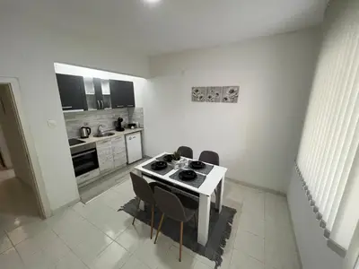 a kitchen with a table and chairs in a room at Апартамент Рози in Sandanski