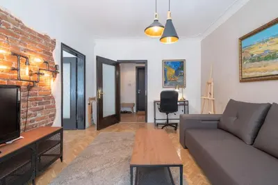 a living room with a couch and a brick wall at Sophisticated Gem with Private parking in Sofia
