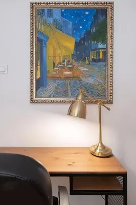 a desk with a lamp and a painting on the wall at Sophisticated Gem with Private parking in Sofia