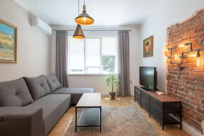 a living room with a couch and a brick wall at Sophisticated Gem with Private parking in Sofia