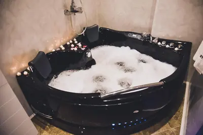a black bath tub filled with snow in a bathroom at NAYS in Madan