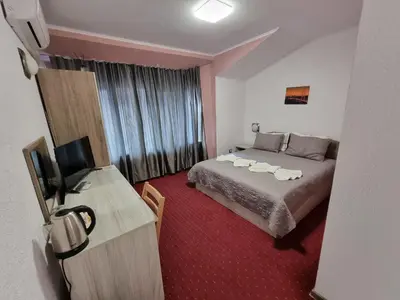 a hotel room with a bed and a television at NAYS in Madan