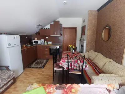 a kitchen with a couch and a table in a room at Ски апартамент, студио Хрис, Лъки Пампорово in Pamporovo